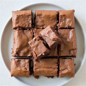 A close-up of fudgy brownies made with Nutella, cut into squares, topped with a dusting of powdered sugar